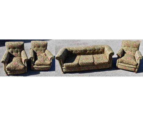 A Victorian Chesterfield type three seater sofa and three matching armchairs, each upholstered in a green floral material, on