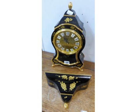 An ornate black and gold Swiss mantel clock by Eluxa with matching wall bracket. 