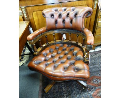 A brown leather button back captains style swivel chair. 