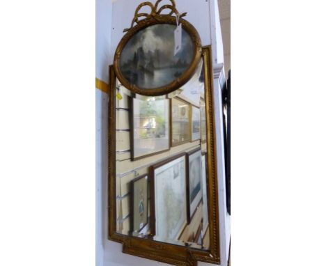 A vintage gilt pier mirror topped with a nautical print. 