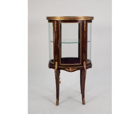 TWENTIETH CENTURY GILT METAL MOUNTED MAHOGANY BIJOUTERIE CABINET, of oval form, the bevel edge glazed top with pierced galler