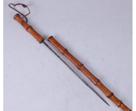 A 19th century sword stick, having a bamboo shaft with white metal top revealing a 29.5cm fullered cruciform blade, 87.5cm.