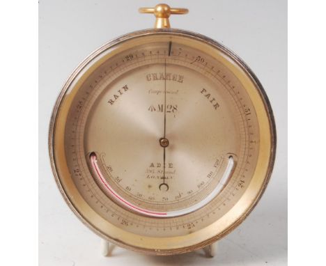 A late 19th century lacquered brass cased cylinderical compensated barometer, the silvered dial with thermometer with broad a