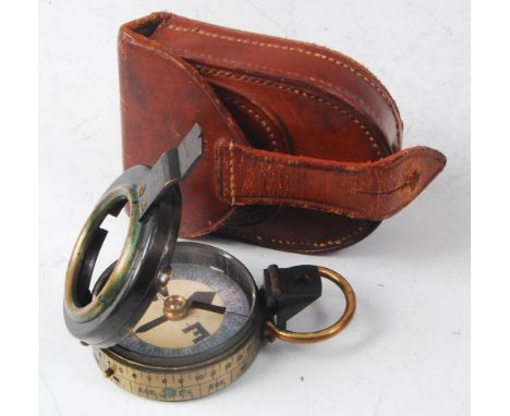 A private purchase brass cased prismatic compass (lacking glass cover), in a stitched brown leather case.