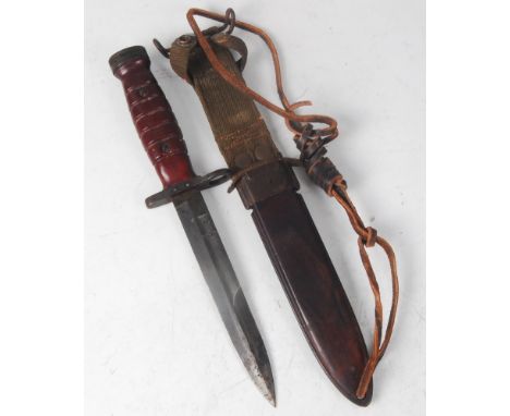 A U.S M4 knife bayonet, having a 16.5cm double edged blade, steel muzzle ring and ribbed two piece wooden grip, housed in a M