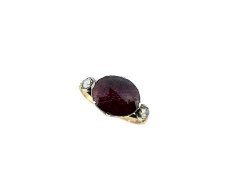 central foil backed oval faceted garnet, 11.1 x 9.3mm, flanked by two rose cut diamonds, approximately 3.4 x 3mm, all held wi