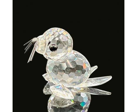 A clear crystal figure of a baby seal on all four flippers with black crystal eyes and black metal whiskers. Swarovski backst