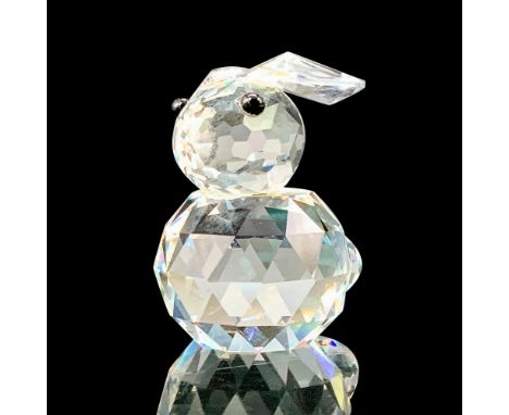 A clear crystal round figure of a rabbit with its ears lowered and black crystal eyes. Swarovski backstamp. This item has its