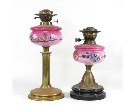A brass oil lamp base, with a painted pink glass font, 45cm high, together with another smaller (2)