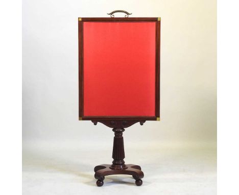 An Irish Regency carved mahogany fire screen, with brass mounts and an adjustable pull out top, on a fluted column an quadrup