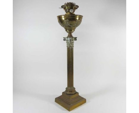 A brass Corinthian column oil lamp, the brass reservoir decorated with swags and bows, 69cm high overall