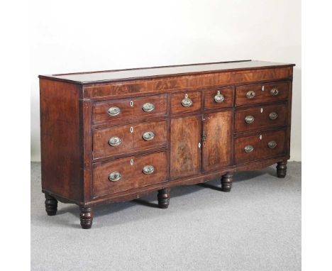 A 19th century mahogany and boxwood strung dresser base, containing an arrangement of eight short drawers, and a pair of cent