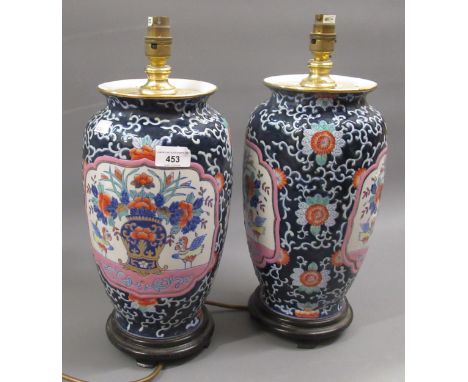 Pair of modern oriental porcelain lamp bases, decorated with panels of flowers on a blue ground, 16ins high overall 