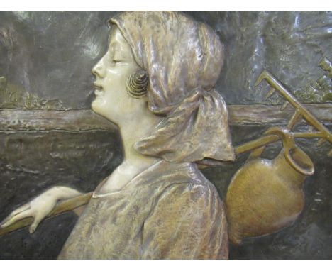Late 19th Century Austrian painted terracotta plaque relief decorated with a portrait of a Dutch girl carrying a rake and pit