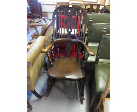 Elm Windsor rocking chair with a hoop stick and pierced splat back, carved panel seat and turned supports with stretchers, th