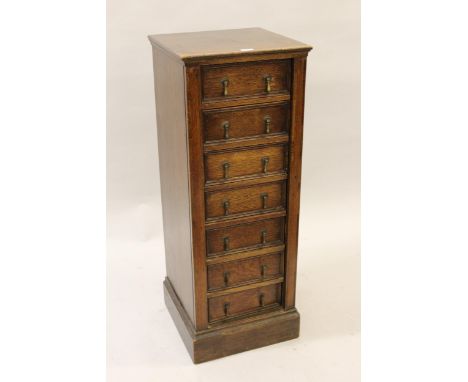 1930's Oak Wellington chest of seven small drawers with drop handles on a plinth base, 16ins square x 42ins highDrawers funct