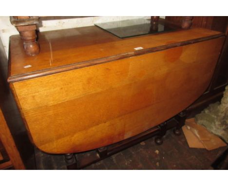 Early 20th Century oak drop leaf gate leg table on turned supports, together with a reproduction mahogany serpentine fronted 