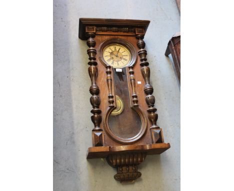 Walnut cased Vienna style wall clock, the enamel dial with Roman numerals and two train movement above a pendulum window, 41i
