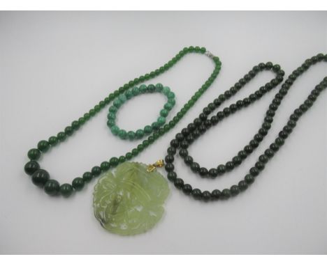 20th Century jade pendant with pierced and carved decoration, 55mm diameter approximately together with two dark green jade b