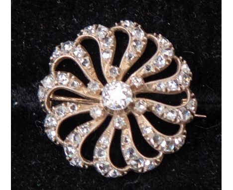 A diamond stylised flower head brooch, central round old-cut diamond approx 0.50 carat, the openwork surround comprising fift