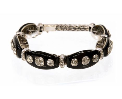 An Art Deco diamond and black onyx white gold bracelet, the six barrel shaped black onyx links each rub over set with three c