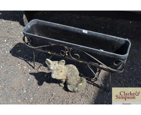 A wrought iron garden planter and a concrete garden ornament