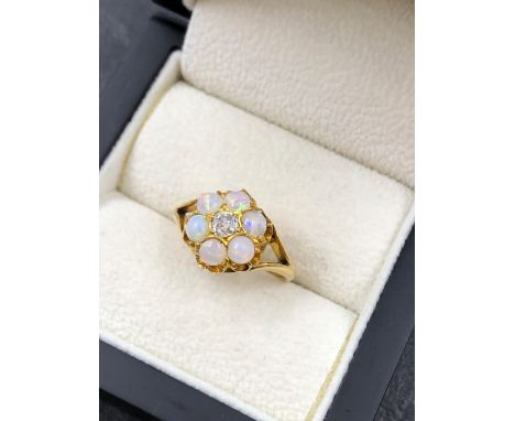 AN EARLY 20th CENTURY OLD CUT DIAMOND AND OPAL SEVEN STONE CLUSTER RING, THE SHANK STAMPED 18ct, ASSESSED AS 18ct YELLOW GOLD