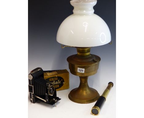 A VINTAGE BRASS PARAFFIN LAMP WITH WHITE GLASS SHADE, A KODAK JUNIOR CAMERA IN ORIGINAL BOX, AND A MODERN SMALL TELESCOPE.