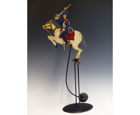 A VINTAGE ROCKING AUTOMATON CAVALRY CHARGER.