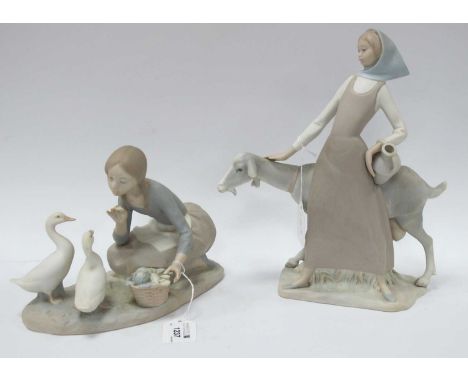 Lladro Figure of Young Girl with Goat, carrying ewer, 29cm high, together with another of a girl feeding ducks, both in a mat
