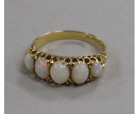 A late Victorian 18ct gold and graduated five stone white opal half hoop ring, size P.