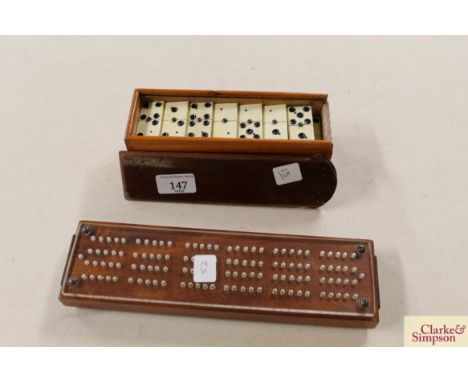 A box of bone dominoes and a cribbage marker 
