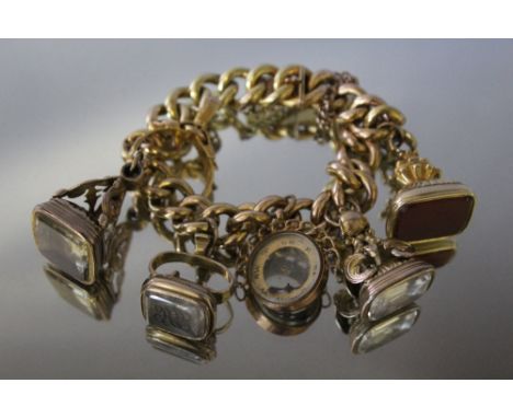 A GOLD FOB SEAL CHARM BRACELET, the bracelet stamp is indistinct but possibly 15ct, set with four fobs, a damaged compass cha