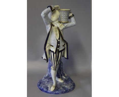 A ROYAL WORCESTER FIGURAL CANDLESTICK, modelled as a classical gentleman in period dress holding a basket, printed mark to th