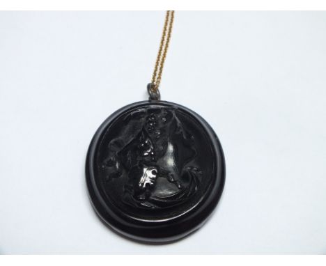 A JET CAMEO PENDANT ON 9CT GOLD CHAIN, W 4 cm