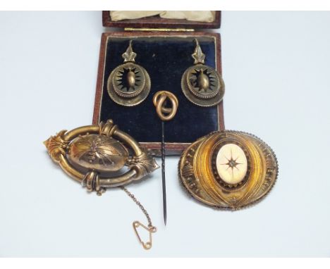 FOUR ITEMS OF ANTIQUE YELLOW METAL JEWELLERY, comprising a yellow metal memorial brooch, another gemset brooch, a pair of dro