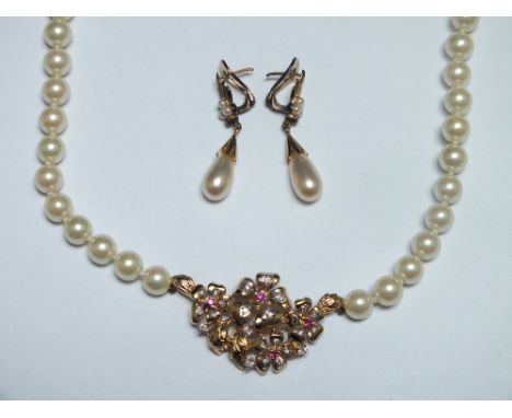 A MODERN PEARL AND GEMSET NECKLACE, the central yellow metal decorative panel set with red and clear gemstones, the safety ch