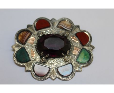 A LARGE HALLMARKED SCOTTISH SILVER SAMPLE BROOCH BY WARD BROTHERS - GLASGOW 1954, set with a large central amethyst, makers m