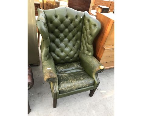 A GREEN LEATHER WING AND BUTTON BACK ARMCHAIR 