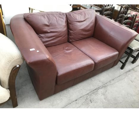 A BROWN LEATHER TWO SEATER SOFA 