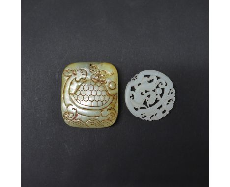 A Chinese carved mutton fat jade dragon amulet, dia. 5cm, together with a further jade amulet.