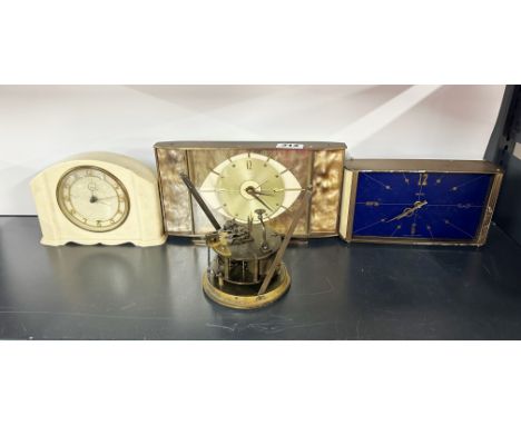 A cream Bakelite mantle clock with two vintage brass mantle clocks and a 19th century Belgian clock movement.