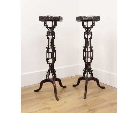 A pair of Chippendale Revival torchères,c.1900, each with a pierced fret-carved octagonal galleried top and similarly carved 