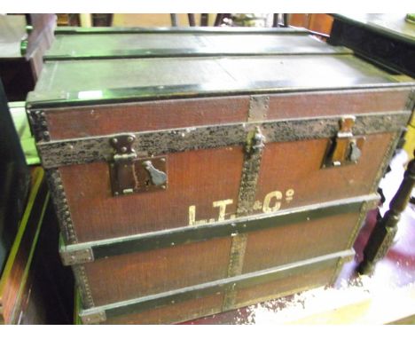 A vintage fibre and wooden lathe bound travelling trunk with hinged lid, the lined interior with rectangular paper label adve