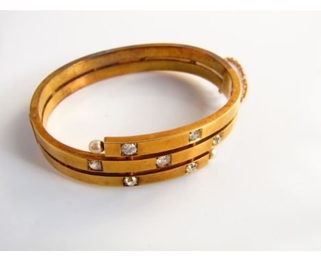 A late Victorian/Edwardian stylised bypass bangle, the central band set with three old-cut diamonds, highlighted with two fur