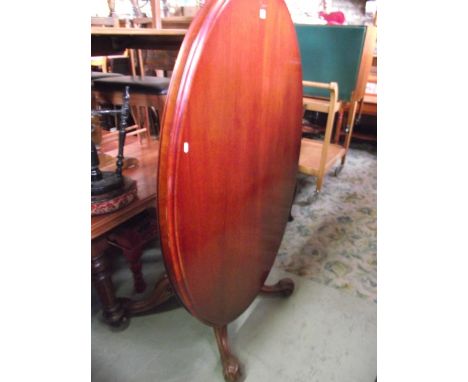 A Victorian walnut tilt top breakfast table of oval form with moulded outline, central pillar and scrolled quadruped with aca