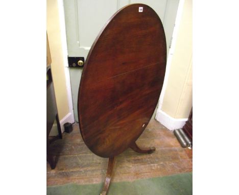 An early 19th century mahogany breakfast table, the top of oval form and with reeded borders, raised on a vase shaped pillar 