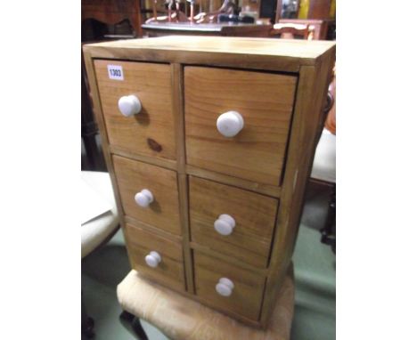 A small stripped pine bank of six deep drawers with white glazed ceramic button knob handles together with a small vintage st