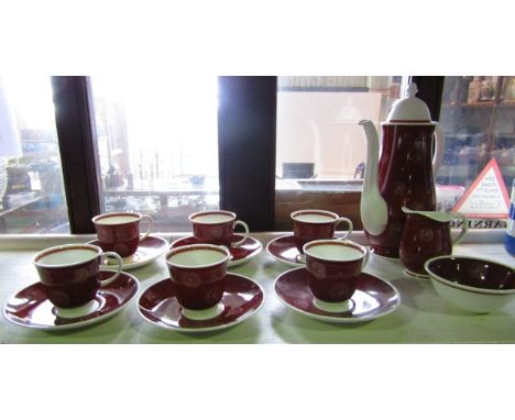 A Susie Cooper coffee service with white spiral decoration on a brick red ground comprising coffee pot, cream jug, sugar bowl