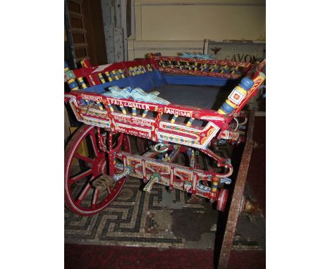 A vintage Eastern European folk art dog cart, with brightly hand-painted finish, sprung chassis, spoke wheels and iron rims (